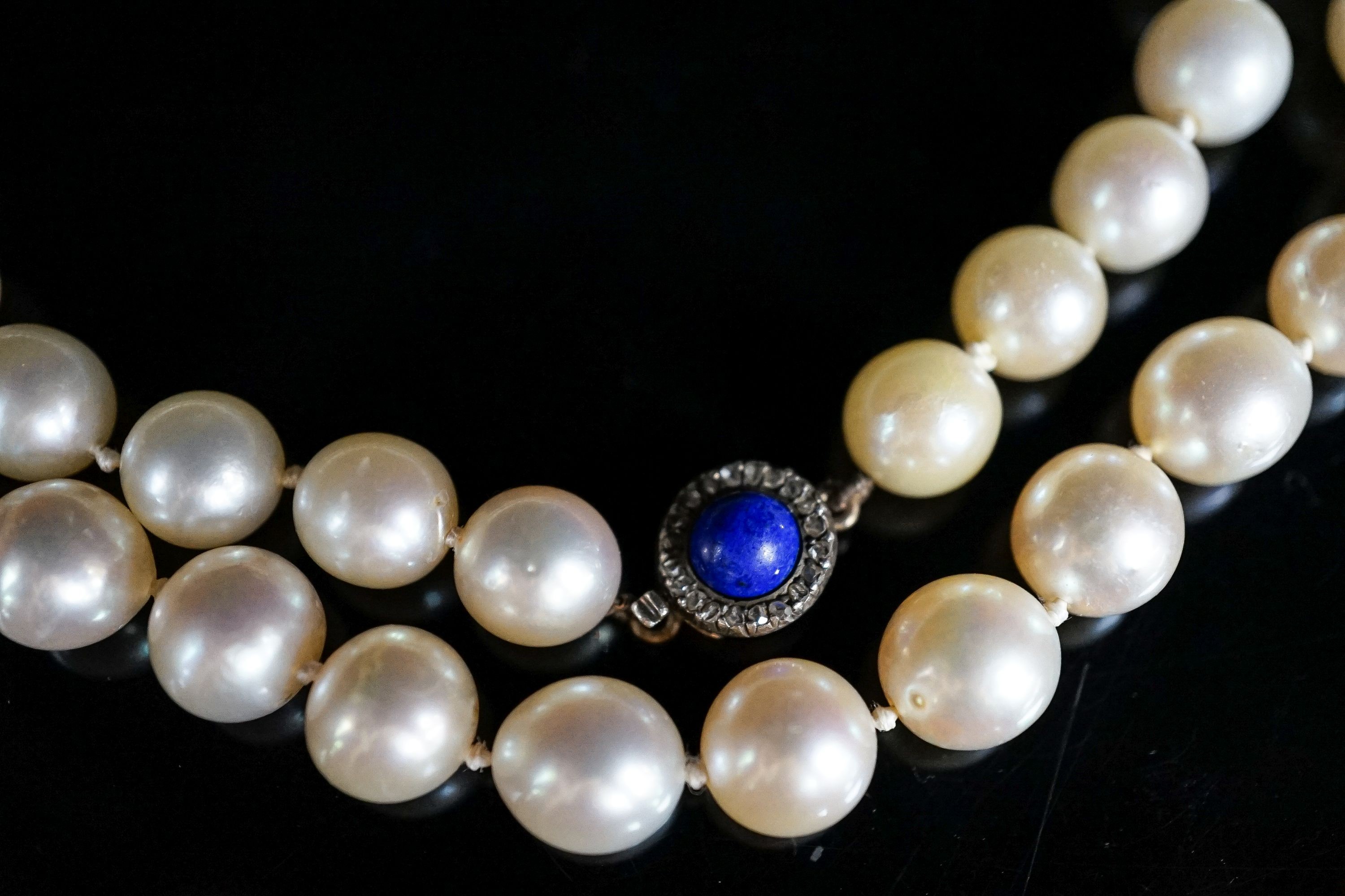 A single strand cultured pearl necklace, with yellow metal, lapis lazuli and diamond set clasp, 63cm, gross weight 67.1 grams.